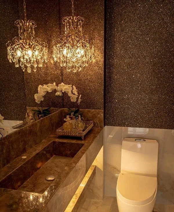 Lavabo com papel de parede de mica cintilante, lustres de cristal e bancada de mármore