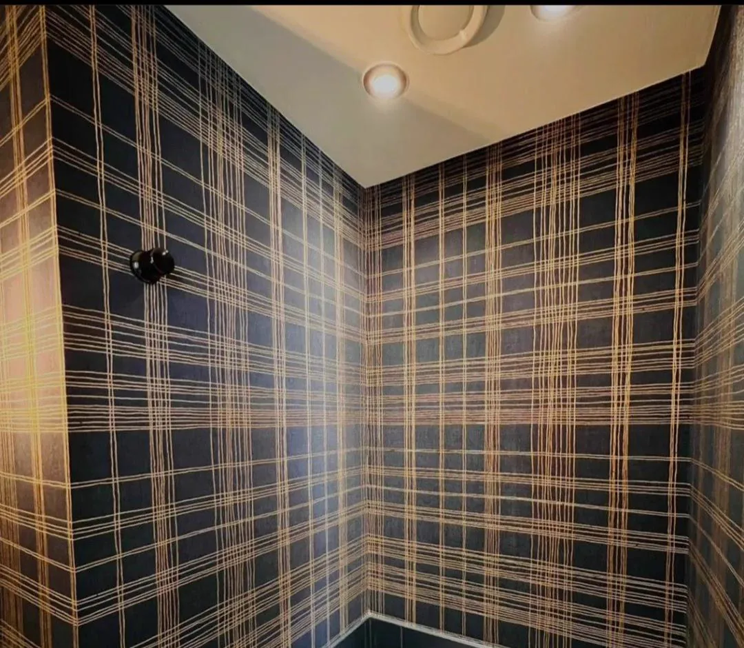 Lavabo forrado com papel de parede xadrez azul-marinho e dourado